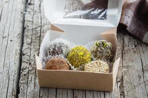 Healthy energy vegan raw balls- dried fruits, nuts with coconut chips, cacao, flax seeds, pistachios photo