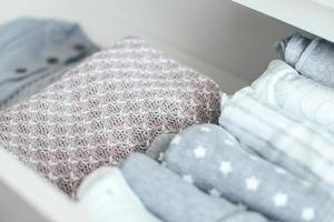 Baby or newborn things of white, blue, grey colors in drawer. Lady fly system, kondo konmary concept photo