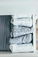 Baby or newborn things of white, blue, grey colors in drawer. Lady fly system, kondo konmary concept photo