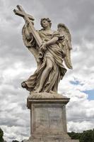 A statue holding a cross on rome bridge photo