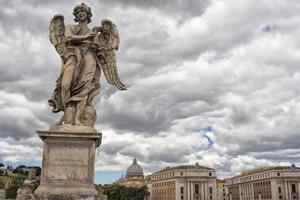 A statue on rome bridge with vatican background photo