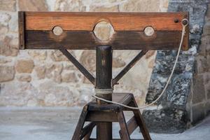 Old pillory on castle stone wall background photo