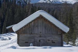 antigua cabaña de madera cubierta de nieve foto