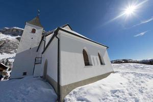 vista de la iglesia de dolomitas en tiempo de nieve de invierno foto