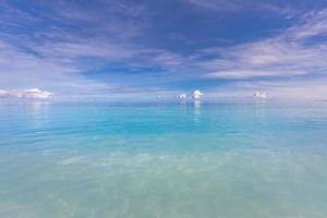 Blue sky over sea or ocean water surface. Idyllic sea and sky template. Tropical beach landscape and seascape, inspirational, tranquil, and relaxing sea view. Horizon, clouds and soft waves photo
