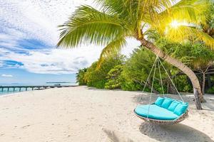 Couple travel honeymoon beach background as summer landscape with tranquil beach swing or hammock and white sand and calm sea for beach banner. Vacation and summer holiday concept. Leisure lifestyle