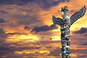 A totem wood pole in the gold cloudy background photo
