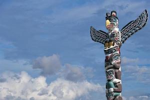 Totem wood pole in the blue cloudy background photo