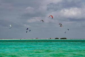 kite surfers on tropical polynesian beach aitutaki cook islands photo