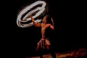 Fire dance Cook Islands polynesian dancer with pole of flames photo