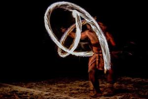 Fire dance Cook Islands polynesian dancer with pole of flames photo