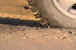 offroad car tire detail on sand beach photo