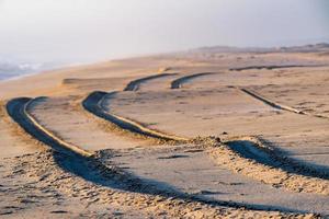 offroad car tire  track detail on sand beach photo