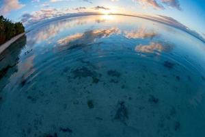 Sunset on polynesian white sand beach photo