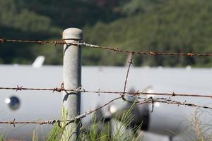 military airplane behind barbed wire photo