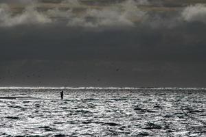 man walking on water at sunset photo