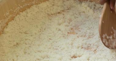 Kabuki Sushi Rice Preparation - Wet Rice Mixture With Vinegar In A Large Wooden Container Using A Wide Wooden Spoon - Closeup Shot video