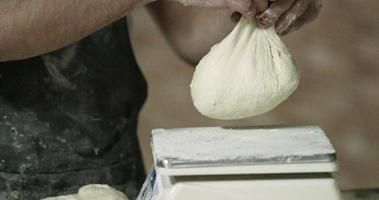 mains d'un boulanger pesant la pâte pétrie sur une balance de cuisson dans la boulangerie. - photo en gros plan video