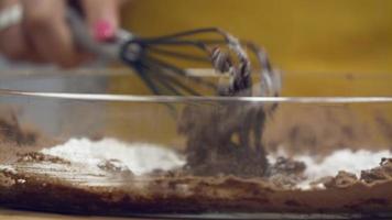 leiria, portugal - mujer golpeando la mezcla de chocolate con un batidor en cámara lenta - toma de primer plano video
