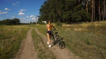 menina atlética com bicicleta na floresta video