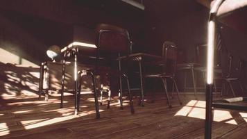 View to classroom with tables and small blackboard and grungy walls photo