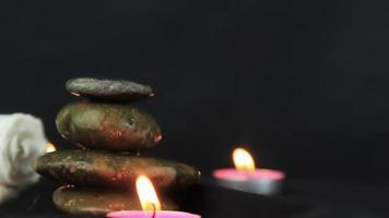 pedras de massagem com velas acesas em vista de perto usadas em tempo de relaxamento e ioga.