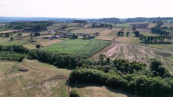 panoramico Visualizza di rurale paesaggio con abitazioni e i campi nel il soleggiato giorno. aereo tiro video