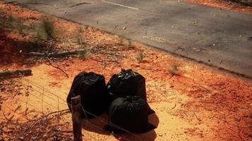 closeup of full trash bags on the sand photo