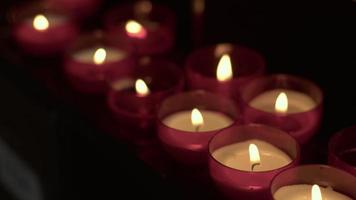 Souhait rouge et prier des bougies dans une église catholique video