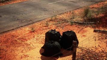 closeup of full trash bags on the sand photo