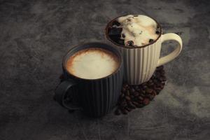 Hot latte and iced latte with coffee beans on concrete background. photo