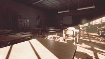 View to classroom with tables and small blackboard and grungy walls photo