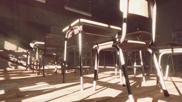 View to classroom with tables and small blackboard and grungy walls photo