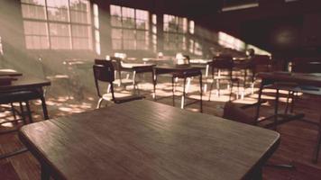 View to classroom with tables and small blackboard and grungy walls photo