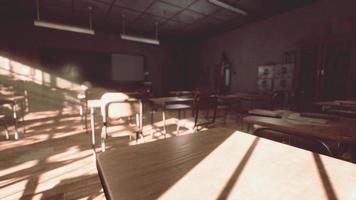 View to classroom with tables and small blackboard and grungy walls photo