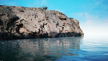 Tropical rock island against blue sky and sea photo