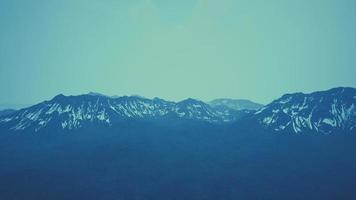 paisaje dramático de picos de las altas montañas del cáucaso y nieve blanca foto