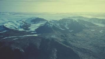 large snow patch left over on the volcanic rock field of a mountain in summer photo