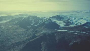 large snow patch left over on the volcanic rock field of a mountain in summer photo