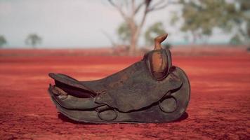 Old decorated mexican saddle lying on sand photo