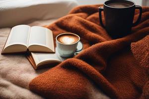 un libro sentado encima de una cama junto a una taza de café foto