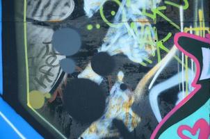 fragmento de primer plano de un dibujo de graffiti aplicado a la pared con pintura en aerosol. imagen de fondo de una composición moderna de líneas y áreas coloreadas. concepto de arte callejero foto