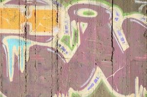 Close-up fragment of a graffiti drawing applied to the wall by aerosol paint. Background image of a modern composition of lines and colored areas. Street art concept photo