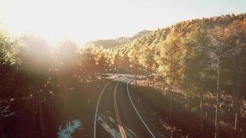 road and yellow mountain forest at sunset photo