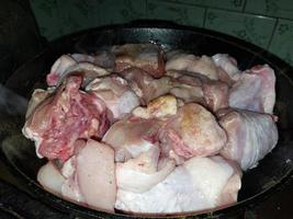 Cooking chopped chicken with an ax in a pan photo