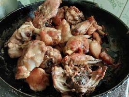 Cooking chopped chicken with an ax in a pan photo