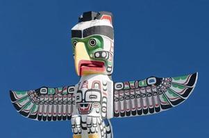 A totem wood pole in the blue cloudy background photo