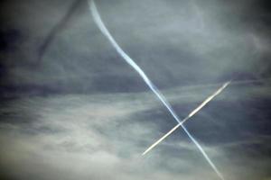 Airplane flying in the blue sky among clouds and sunlight photo