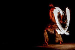 Fire dance Cook Islands polynesian dancer with pole of flames photo