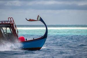 maldivian dhoni boat in blue ocean photo